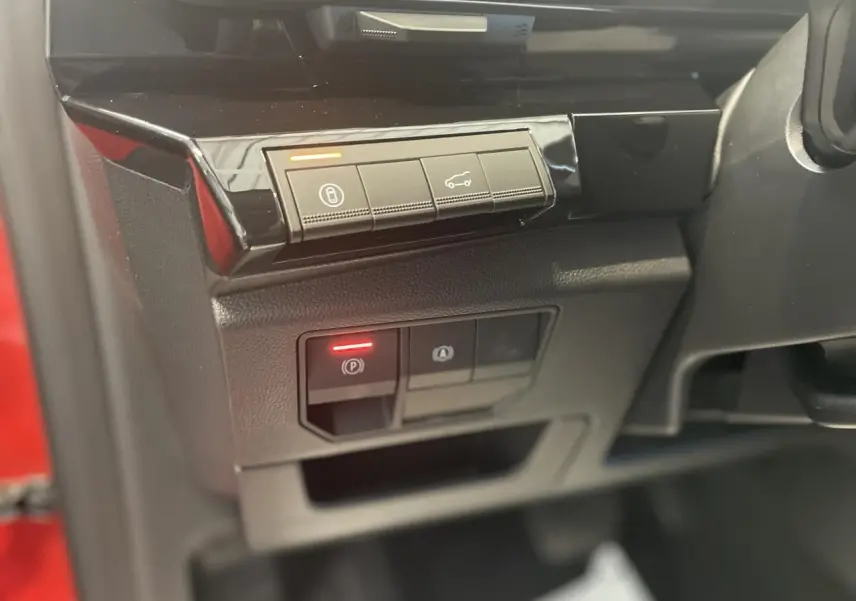 Détail des commandes sur la gauche du volant d'une Renault Rafale rouge avec finition intérieure noire brillante.