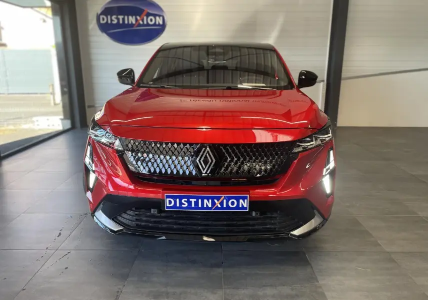 Vue frontale du Renault Rafale 2025 rouge à toit noir avec calandre noire et feux LED allumés en showroom.