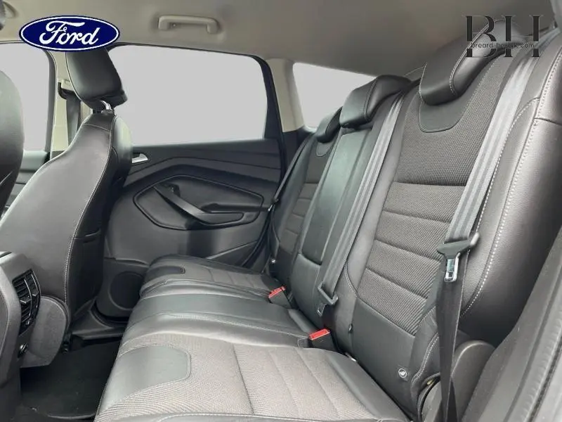 Vue latérale intérieure des sièges arrière en cuir noir du Ford Kuga 2015, avec ceintures de sécurité visibles.