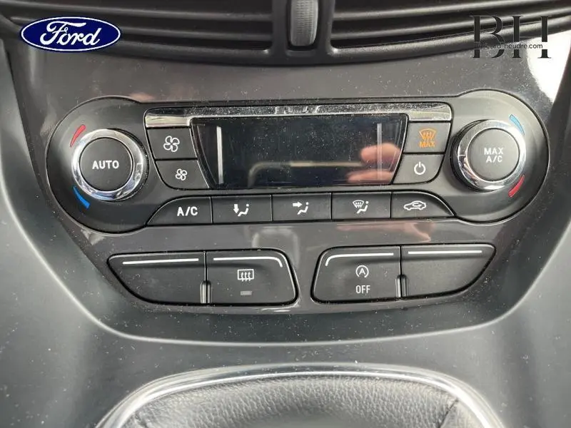 Vue rapprochée de la console centrale du Ford Kuga 2015, montrant les commandes de climatisation automatique et ventilation.