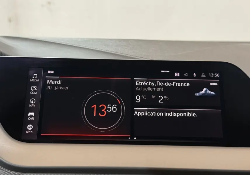 Affichage numérique central tactile de la BMW Série 1 116d Business Design, avec heure, météo et menus visibles.