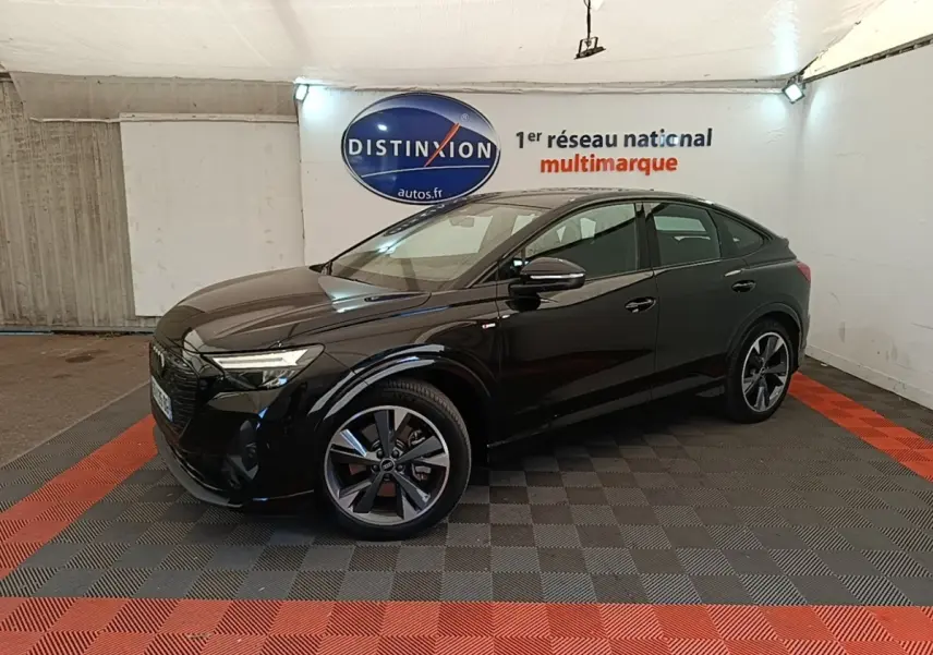 Audi Q4 E-Tron Sportback noir vue 3/4 avant droit en intérieur avec jantes S Line distinctives.