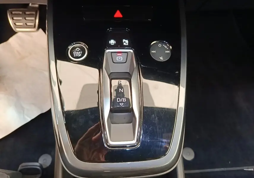 Gros plan sur la console centrale noire de l’Audi Q4 E-TRON Sportback avec levier de vitesses automatique et bouton start/stop.