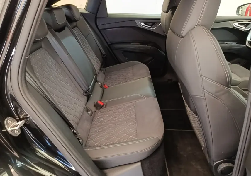 Vue intérieure côté gauche sur la banquette arrière en cuir noir matelassé de l'Audi Q4 E-Tron Sportback 2023.