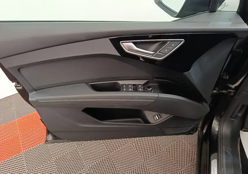 Vue intérieure de la porte côté conducteur de l'Audi Q4 E-TRON Sportback noire avec commandes de vitres et verrouillage.