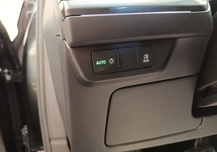 Détail des commandes d'éclairage avec bouton auto dans l'habitacle noir de l'Audi Q4 E-TRON Sportback 2023.