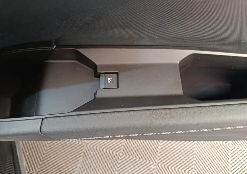 Détail de la commande de lève-vitre sur la porte intérieure côté conducteur d’un Audi Q4 E-TRON Sportback noir.