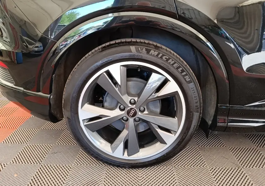 Gros plan sur la roue arrière droite noire d’un Audi Q4 E-TRON Sportback avec jante alliage et pneu Michelin.