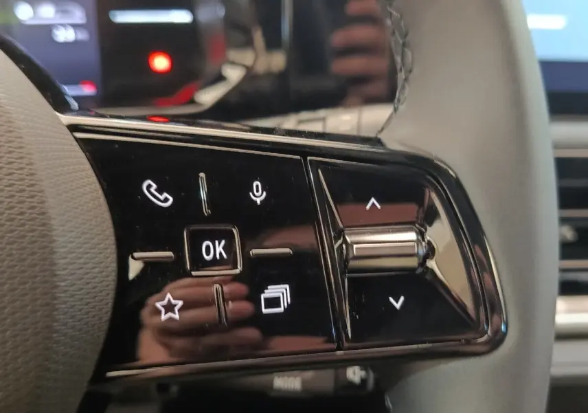 Gros plan sur les commandes multifonctions du volant côté gauche de la Renault Clio bleu évolution TCe 115 ch 2026.