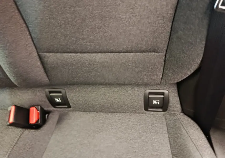 Détail de la banquette arrière grise de la Renault Clio avec fixation Isofix et boucle de ceinture rouge visible.