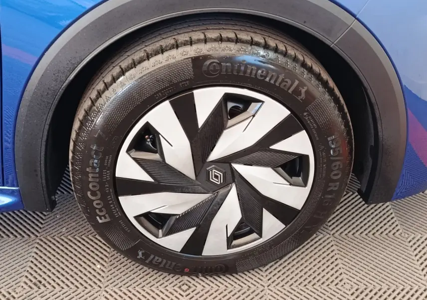 Gros plan sur la roue avant droite d’une Renault Clio bleu 2026 avec jante au design géométrique noir et argent.