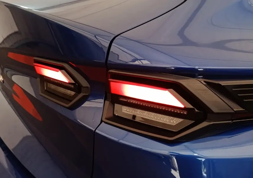 Gros plan sur les feux arrière LED rouges du côté gauche d’une Renault Clio bleu intense, modèle 2026.