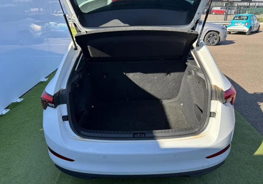 Coffre ouvert vu de l'arrière d'une Skoda Scala blanc glacier 2024, montrant l'espace de chargement vide.