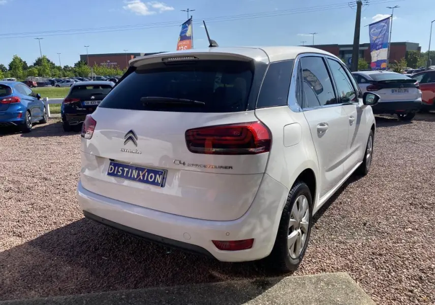 Vue 3/4 arrière droite d'une Citroën C4 Spacetourer blanche avec vitres teintées et feux arrière distinctifs.