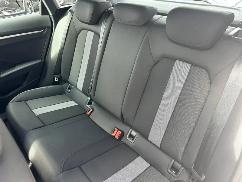 Vue intérieure sur la banquette arrière en tissu noir et gris de l'Audi A3 Sportback 2024 hybride.