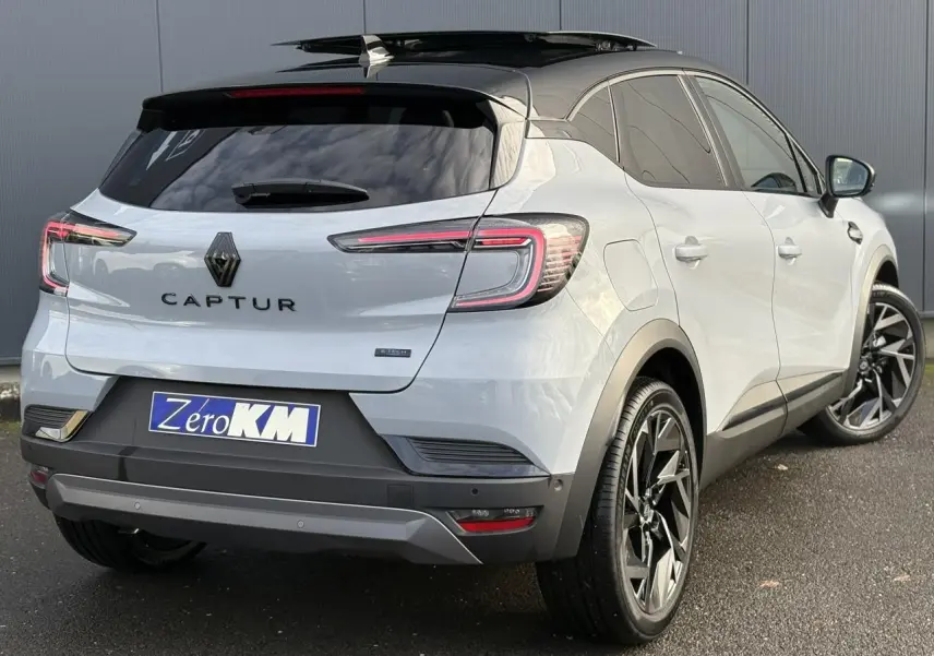 Vue 3/4 arrière droite du Renault Captur gris Rafale avec toit noir ouvrant et jantes noires distinctives.