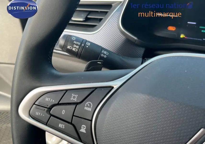 Gros plan sur les commandes au volant du Renault Arkana gris Cassiopée Métal, mettant en valeur les boutons multifonctions.