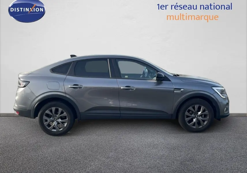 Profil droit du Renault Arkana gris cassiopée métallisé, version 1.3 mild hybrid 140ch avec jantes alliage et feux LED.