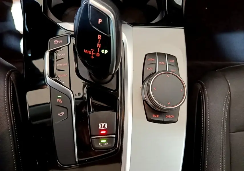 Vue rapprochée de la console centrale noire et argentée du BMW X3 sDrive18d 2019 avec levier de vitesse automatique et molette de contrôle.