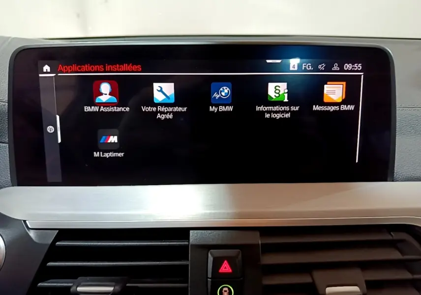 Écran tactile central affichant les applications installées dans l’habitacle d’un BMW X3 noir, vue de face.