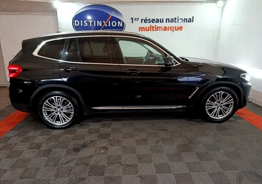 BMW X3 sDrive18d noir vue de profil côté gauche, avec jantes alliage et rails de toit chromés visibles.
