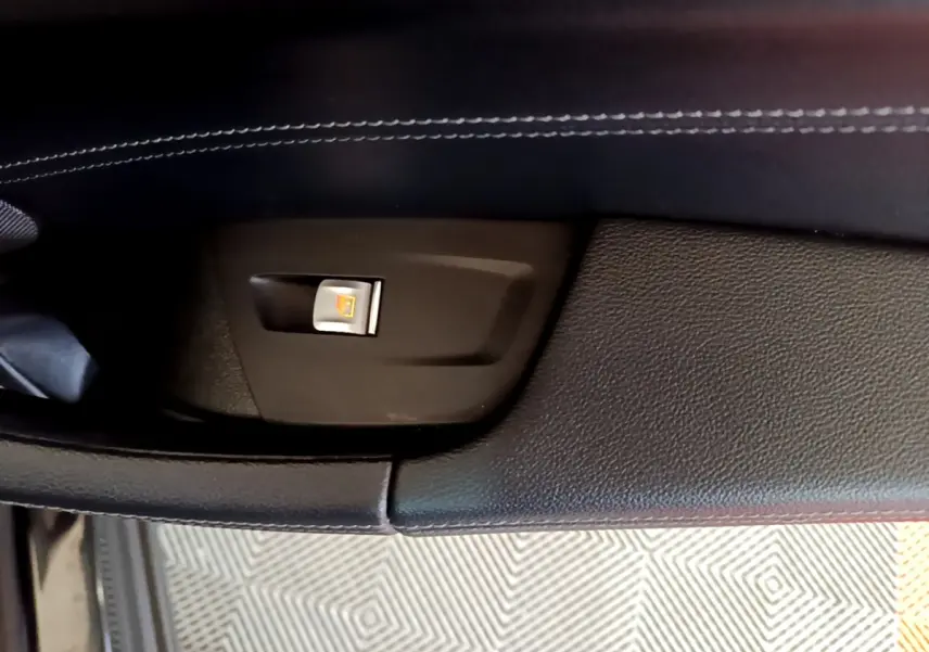 Gros plan sur le bouton de condamnation centralisée sur la porte intérieure noire d’un BMW X3 sDrive18d 2019.