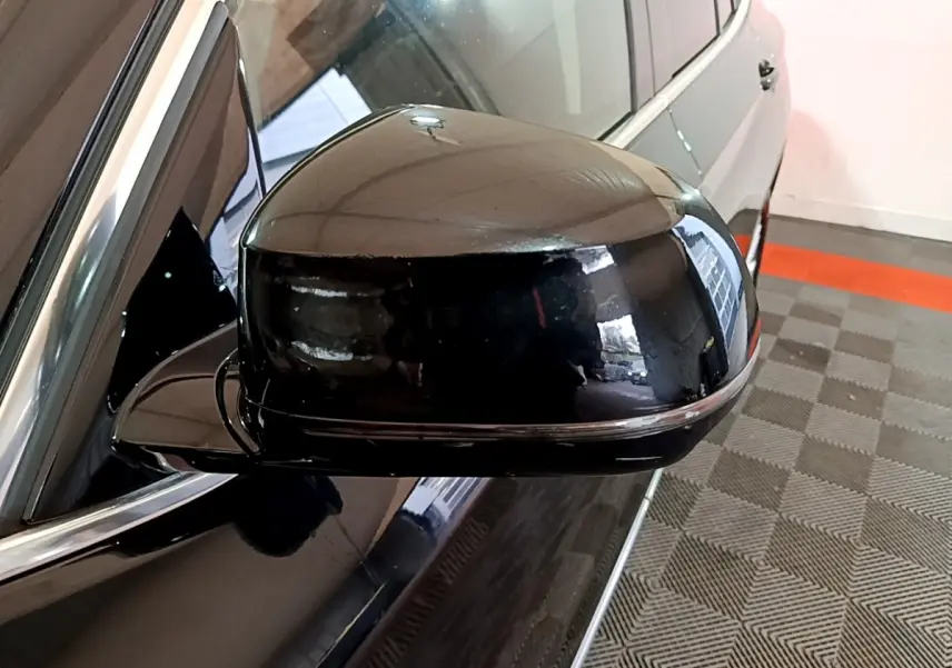 Rétroviseur côté gauche noir brillant d’un BMW X3 sDrive18d Luxury 2019, avec carrosserie noire visible en arrière-plan.