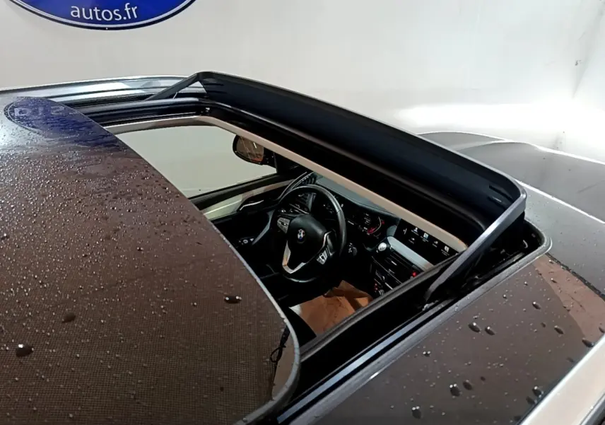 Vue plongeante sur l'intérieur noir d'un BMW X3 sDrive18d 2019 avec toit ouvrant panoramique ouvert.