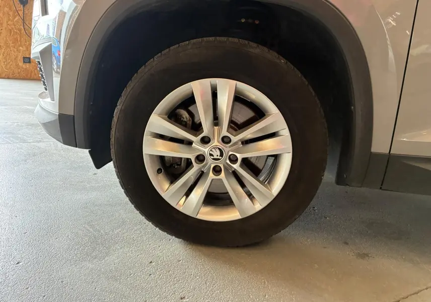 Gros plan sur la roue avant droite d’un Skoda Kodiaq gris clair, mettant en valeur la jante alliage à plusieurs branches.