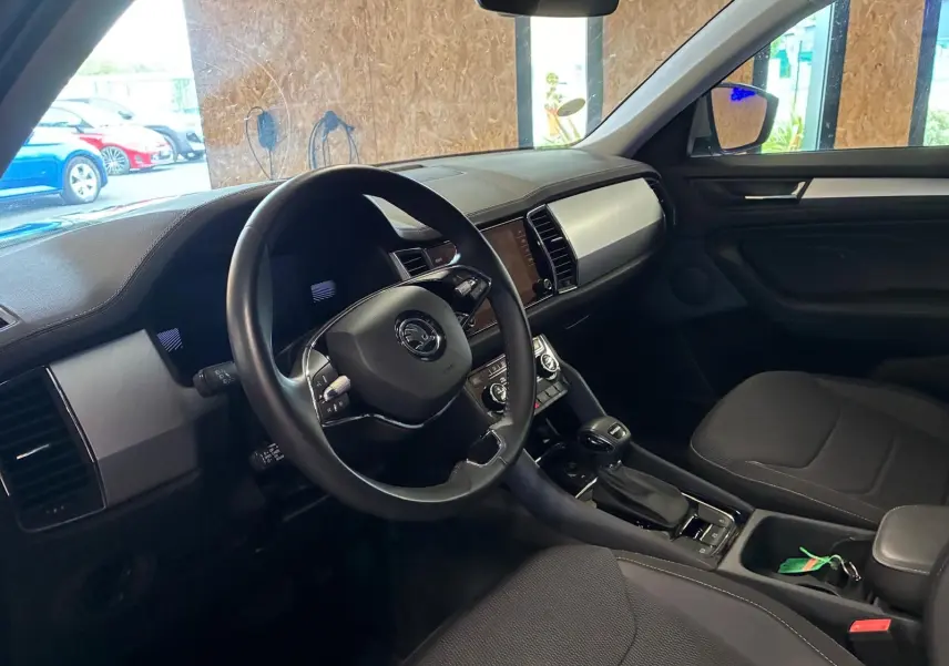 Intérieur noir du Skoda Kodiaq 2023, vue côté conducteur montrant volant, tableau de bord et console centrale.