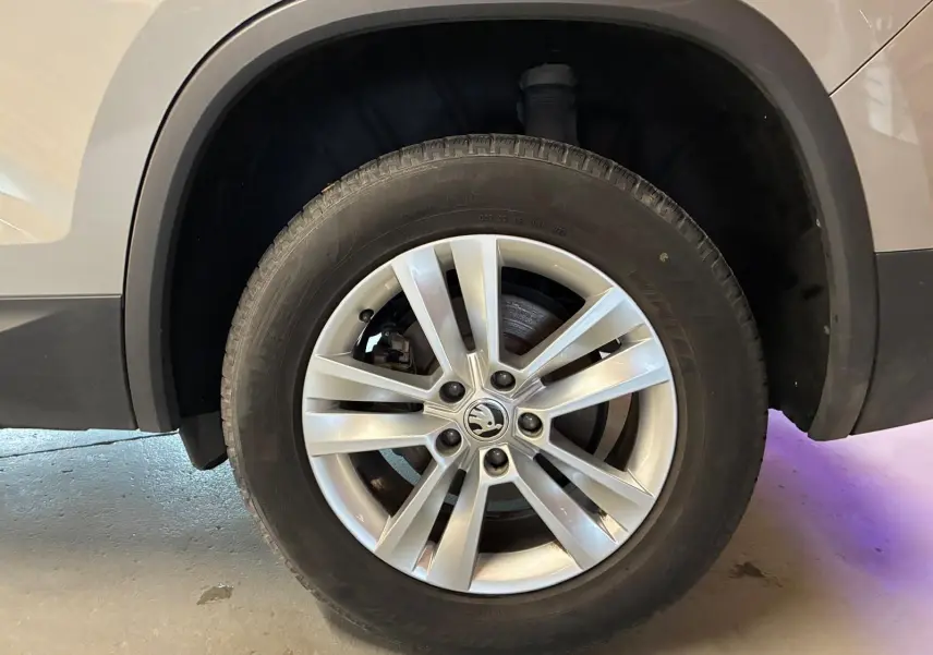Gros plan sur la roue avant droite d'un Skoda Kodiaq gris clair 2023 avec jante alliage à 5 doubles branches.