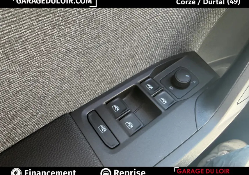 Gros plan sur les commandes des vitres électriques et rétroviseurs côté conducteur d'un SEAT Arona noir, intérieur tissu gris.