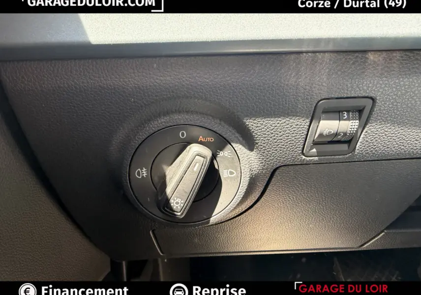 Gros plan sur le bouton de commande des phares et réglage hauteur sur tableau de bord noir d'une SEAT Arona 2025.