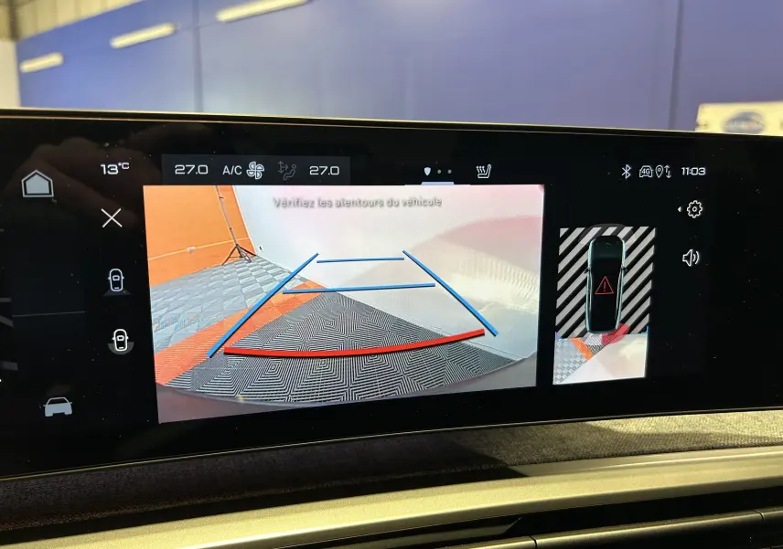Vue caméra 360° montrant un SUV Peugeot 3008 bleu en stationnement intérieur avec lignes d’aide au recul.