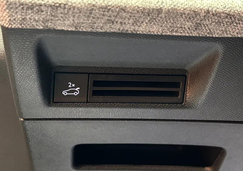 Gros plan sur le compartiment de rangement intérieur éclairé en bleu du Peugeot 3008 III Hybrid 145ch e-DCS6 GT blanc Okenite.