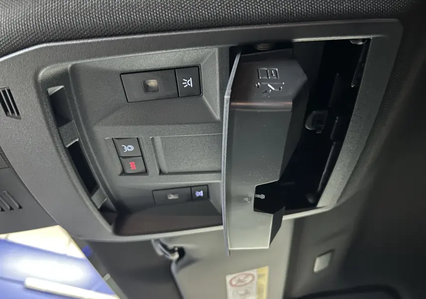 Gros plan sur la plaque de seuil de porte Peugeot en métal brossé, intérieur noir du Peugeot 3008 blanc Okenite.