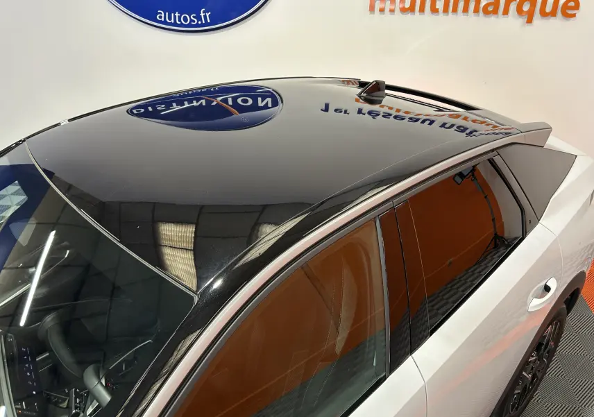 Vue en plongée du toit noir brillant et de la partie latérale blanche du Peugeot 3008 Hybrid 2026 avec vitres teintées.
