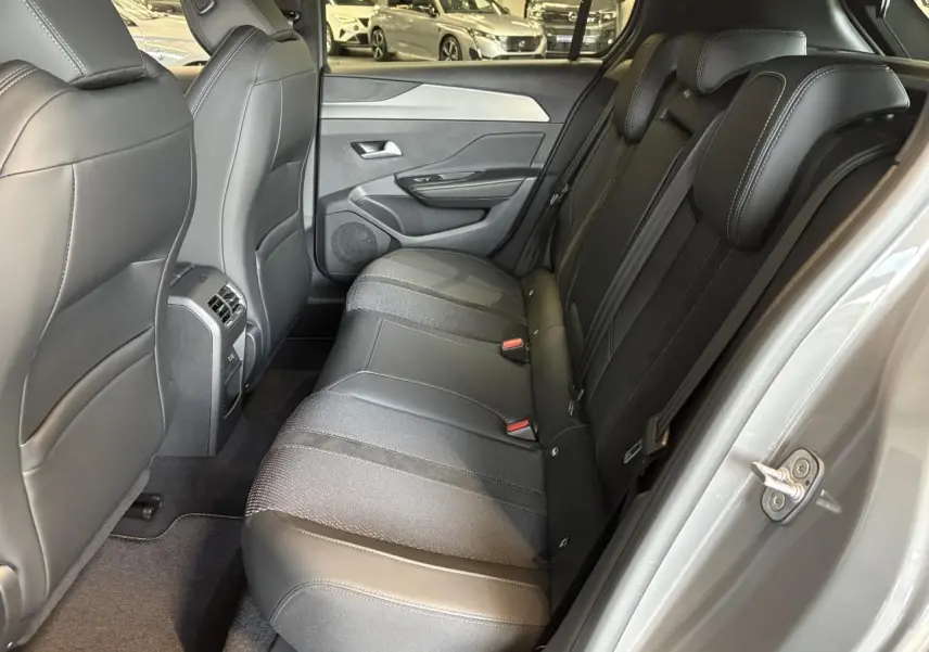 Vue intérieure côté droit sur la banquette arrière en cuir et tissu noir de la Peugeot 308 Gris Sélénium 2025.