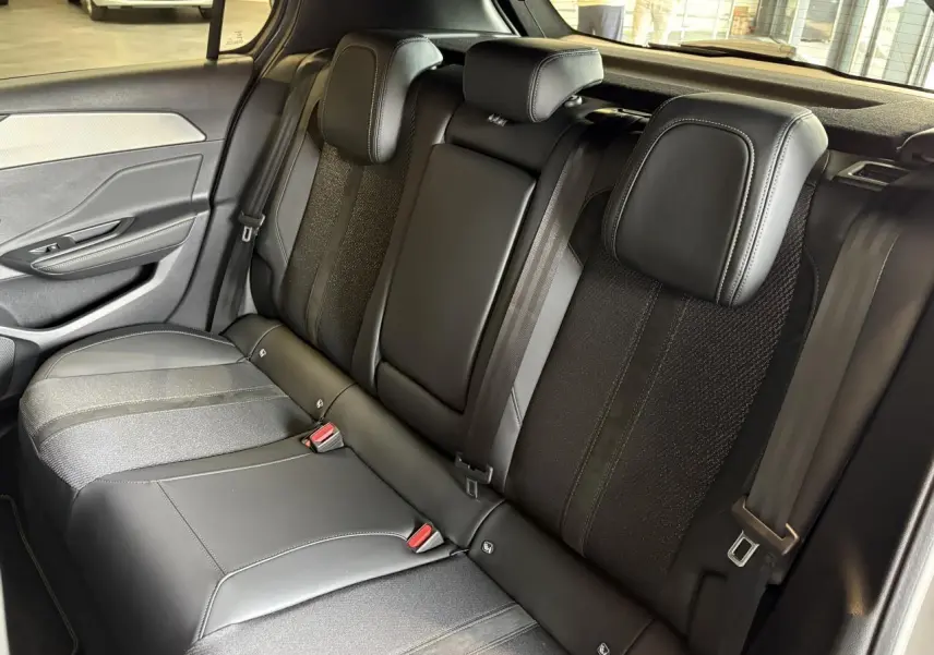 Vue intérieure de la banquette arrière en sellerie tri matières noire de la Peugeot 308 Gris Selenium 2025.