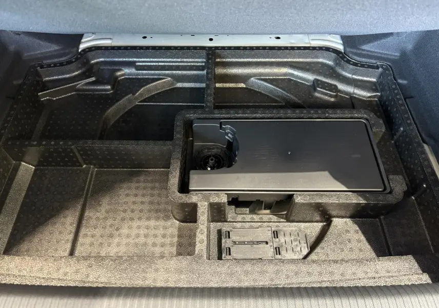 Compartiment de rangement sous le coffre de la Peugeot 308 gris Selenium, avec kit de dépannage pneumatique intégré.