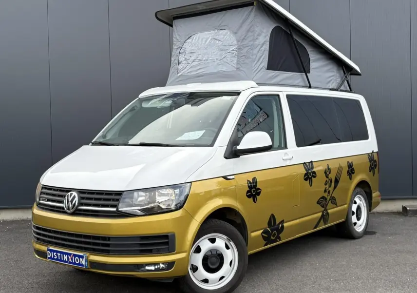 Vue 3/4 avant droite du Volkswagen Transporter aménagé jaune et blanc avec toit relevé et motifs floraux noirs.