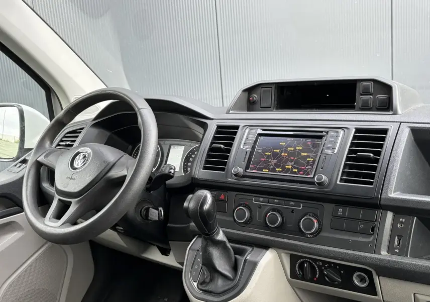 Vue intérieure du tableau de bord du Volkswagen Transporter 2.0 TDI 2017 avec volant, écran tactile et commandes de climatisation.