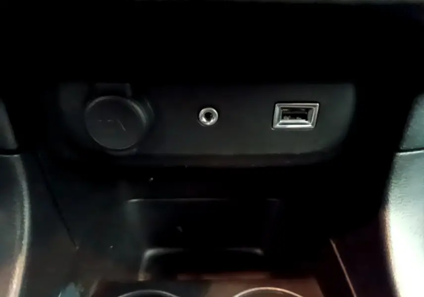 Prise USB, prise jack et prise 12V noires dans la console centrale d'une Citroën C3 PureTech 68 BVM Feel 2018.