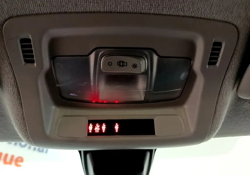 Panneau de contrôle d'éclairage intérieur avec voyants de ceinture allumés dans une Citroën C3 blanche vue de l'habitacle.