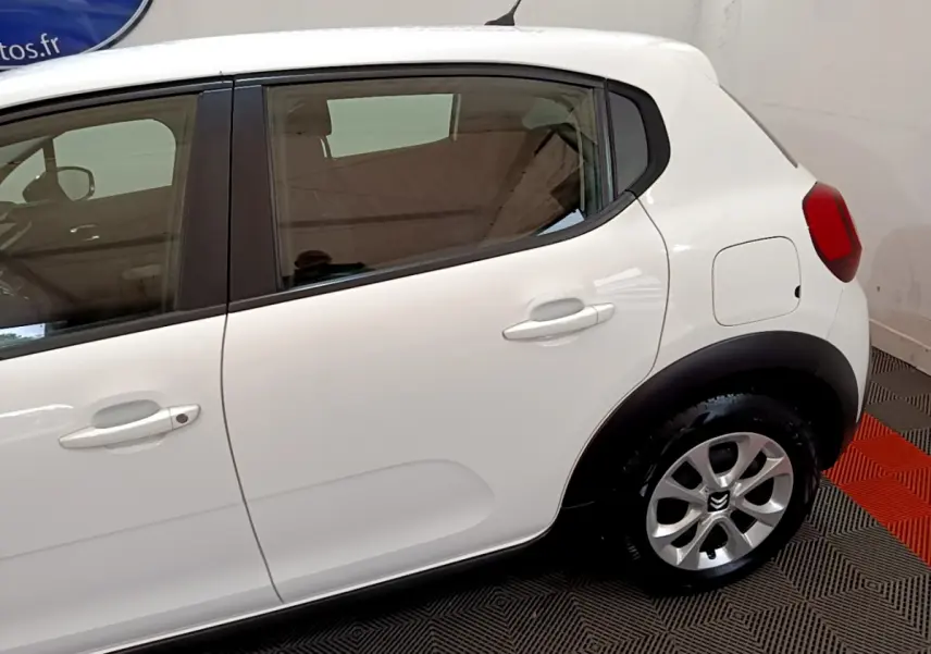 Vue latérale droite d'une Citroën C3 blanche de 2018, mettant en valeur la porte arrière et la roue arrière avec jante alu.