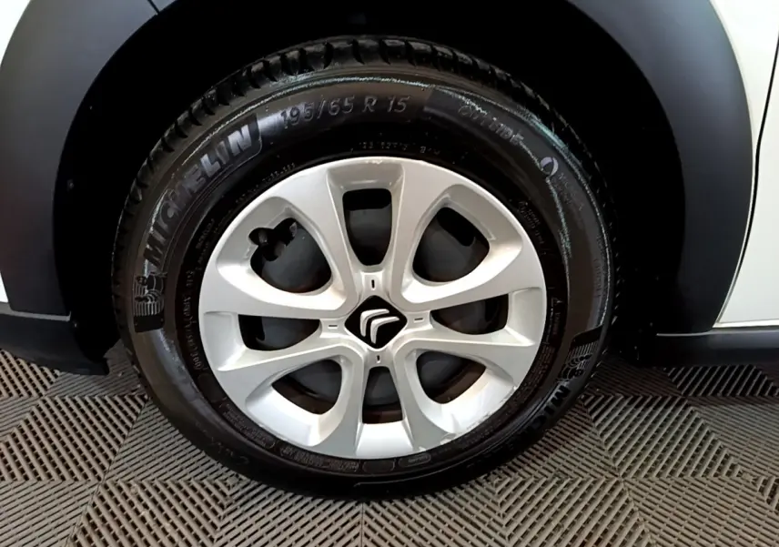 Gros plan sur la roue avant gauche d'une Citroën C3 blanche de 2018 avec jante en alliage et pneu Michelin.