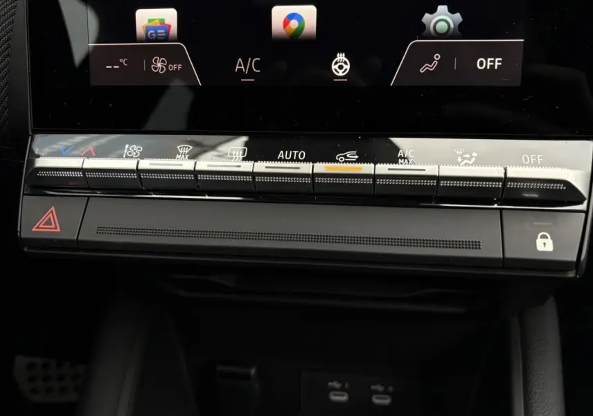 Vue rapprochée de la console centrale noire du Renault Captur 2025 avec commandes climatisation et écran tactile.
