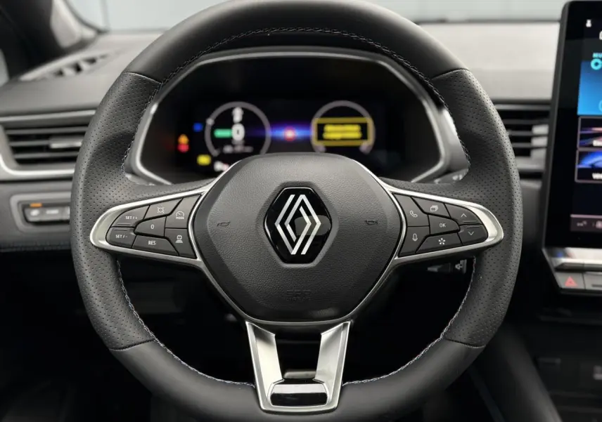 Vue rapprochée du volant noir perforé du Renault Captur 2025 avec logo central et commandes intégrées.