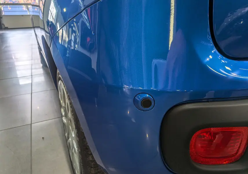 Gros plan sur l'aile arrière droite bleue Italia de la FIAT Panda 1.0 70 CH Hybrid City avec feu arrière et capteur de recul.