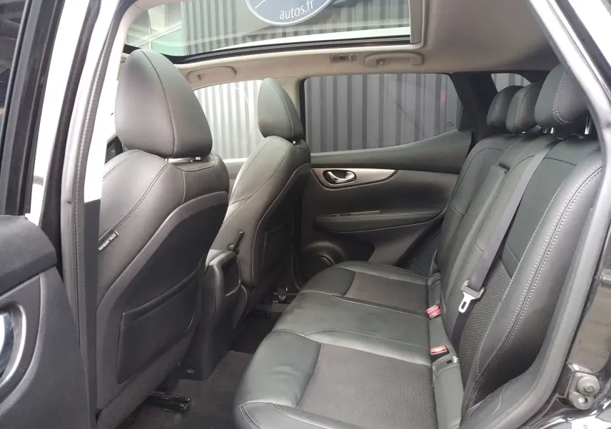 Vue intérieure arrière côté gauche du Nissan Qashqai noir 2019, sièges en cuir noir et toit ouvrant panoramique.